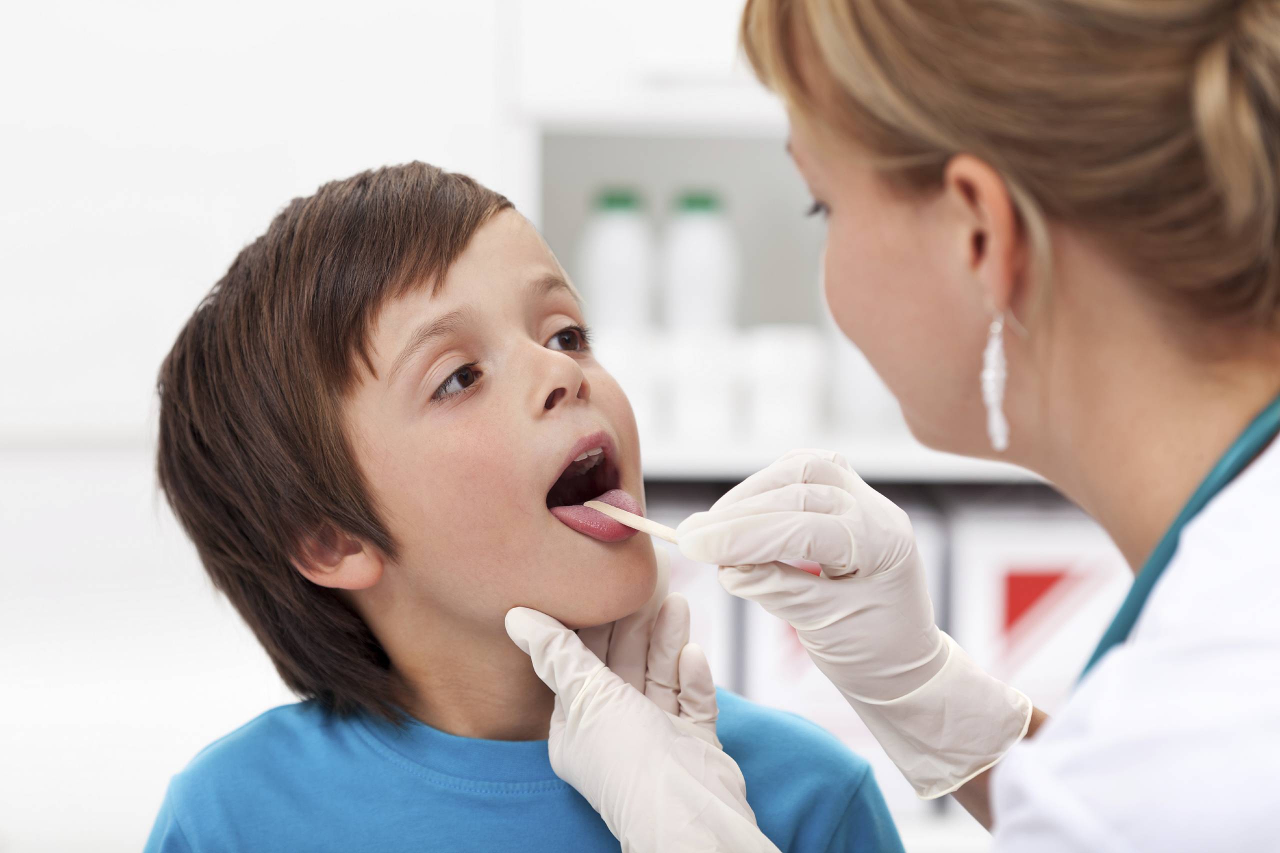 Say aaah - little boy at the physician checking his throat